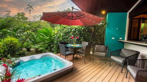a hot tub on a deck with a table and chairs at Bukala Village Lodge in San Ramón