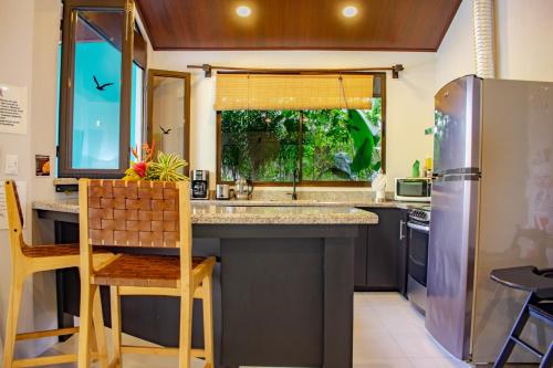 a kitchen with a sink and a refrigerator at Bukala Village Lodge in San Ramón