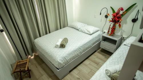 a small bedroom with a bed and a chair at Bukala Village Lodge in San Ramón