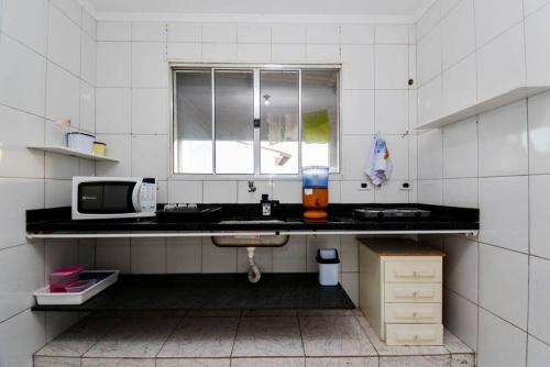 une cuisine avec un évier et un micro-ondes dans l'établissement Apartamento 2 completo, à Guarulhos