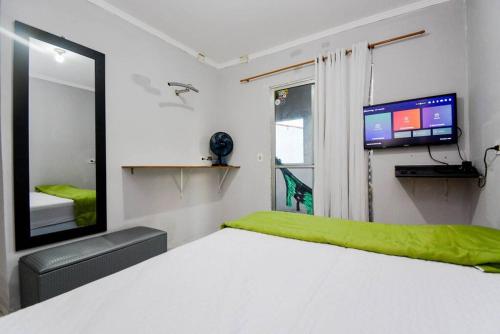 une chambre avec un lit blanc et une télévision dans l'établissement Apartamento 2 completo, à Guarulhos