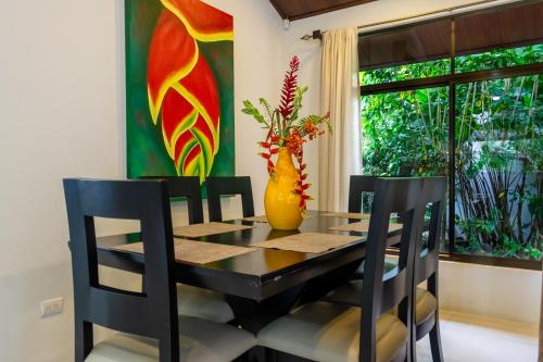 a dining room table and chairs with a vase on the wall at Bukala Village Lodge in San Ramón
