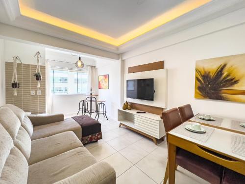 a living room with a couch and a tv at Piscina, churrasqueira, garagem, sauna e academia! in Capão da Canoa