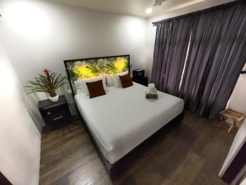 a bedroom with a large white bed and a window at Bukala Village Lodge in San Ramón