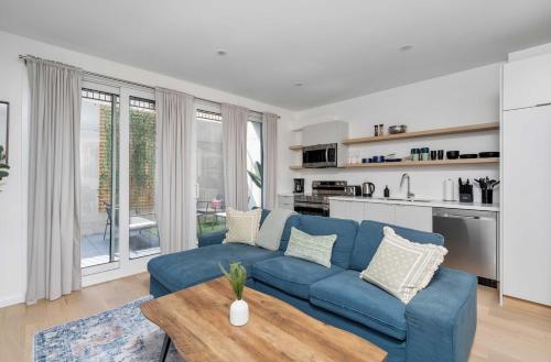 a living room with a blue couch and a table at Hidden Gem - 3 BR Steps to Little Italy and UofT in Toronto