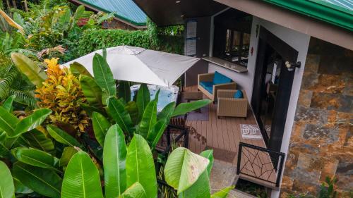 a patio with an umbrella and some plants at Bukala Village Lodge in San Ramón