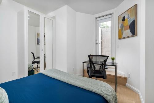 a bedroom with a bed and a table and a chair at Hidden Gem - 3 BR Steps to Little Italy and UofT in Toronto