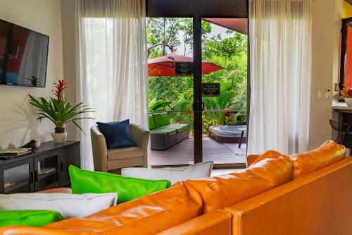 a living room with a couch and a patio at Bukala Village Lodge in San Ramón