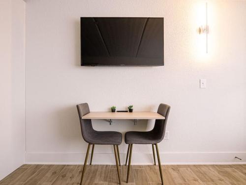 a table with two chairs and a television on a wall at Delightful 1BR Condo Next to Disney With Lake view in Vineland
