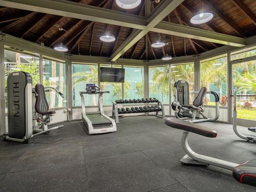 a gym with several exercise bikes in a room with windows at Delightful 1BR Condo Next to Disney With Lake view in Vineland