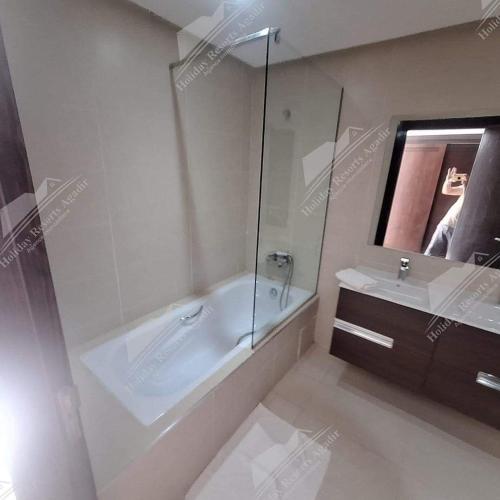 a white bathroom with a tub and a sink at Lemon Grove Villa Taghazout Bay Amda in Taghazout