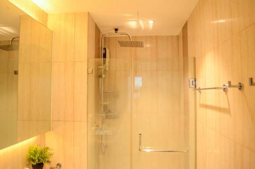 a shower with a glass door in a bathroom at Stylish 1BR Near US Embassy & Luneta with Pool & Gym in Manila