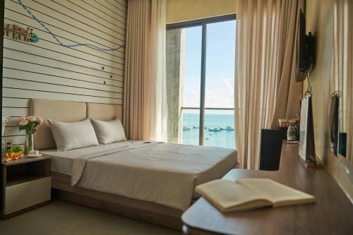 a bedroom with a bed with a view of the ocean at Memory Beach Hotel Phú Quý in Cu Lao Thu