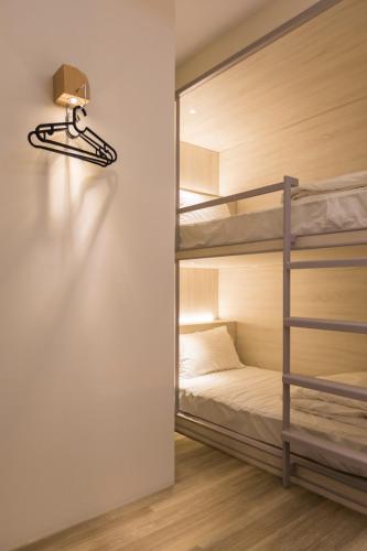 a room with two bunk beds and a light on the wall at Meander 1948 in Taipei