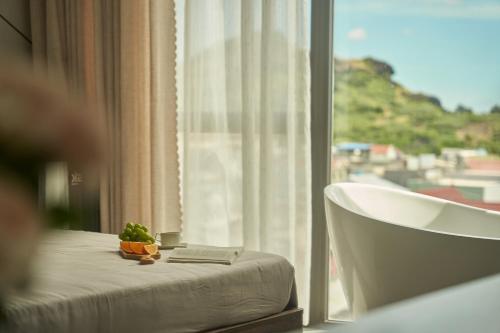 a room with a bed and a window with a plant on it at Memory Beach Hotel Phú Quý in Cu Lao Thu