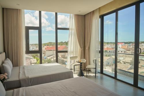 a hotel room with two beds and a large window at Memory Beach Hotel Phú Quý in Cu Lao Thu