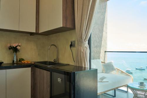 a kitchen with a sink and a couch and a window at Memory Beach Hotel Phú Quý in Cu Lao Thu