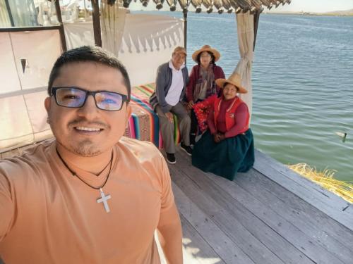 a man sitting on a boat with a group of people at Titicaca villa del sol in Uros