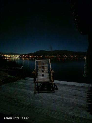 a chair sitting on a dock near the water at night at Titicaca villa del sol in Uros