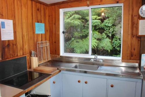 une cuisine avec un évier et une fenêtre dans l'établissement OCEANSIDE - Exclusive & private - Castaway Cottage, à Tuateawa