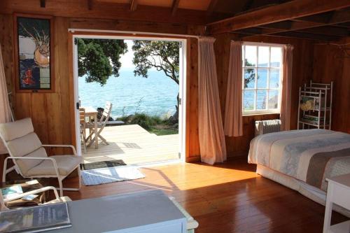 une chambre avec un lit et une vue sur l'océan dans l'établissement OCEANSIDE - Exclusive & private - Castaway Cottage, à Tuateawa