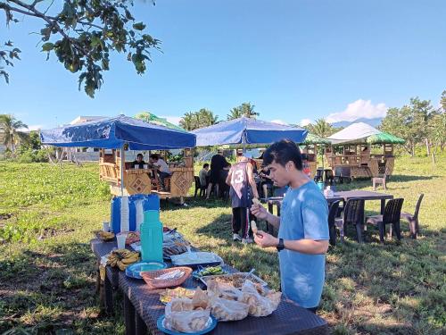 a man standing in front of a table with food at The Waves at Socorro Baler- Hotel A in Reserva