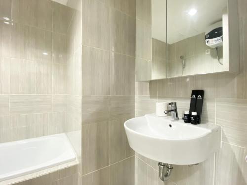 Ванная комната в Cozy Stay 1BR at Vasanta Innopark Apartment By Travelio