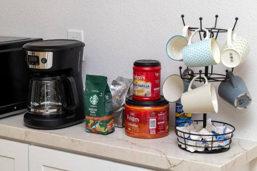 a kitchen counter with a coffee maker and some food at NEW Lux 5BR Villa Near Disney, Knotts, LA, OC with Hot Tub & Games in Fullerton