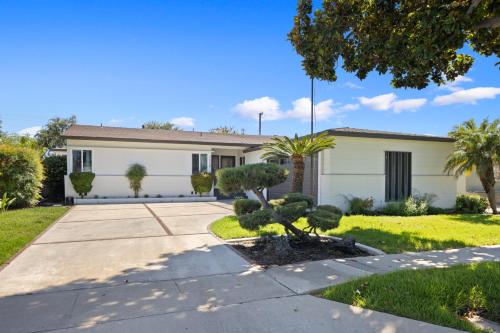 a white house with trees in front of it at NEW Lux 5BR Villa Near Disney, Knotts, LA, OC with Hot Tub & Games in Fullerton