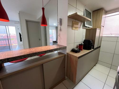 a small kitchen with a counter top and a window at Apto com elevador, muito ventilado e aconchegante in Anil