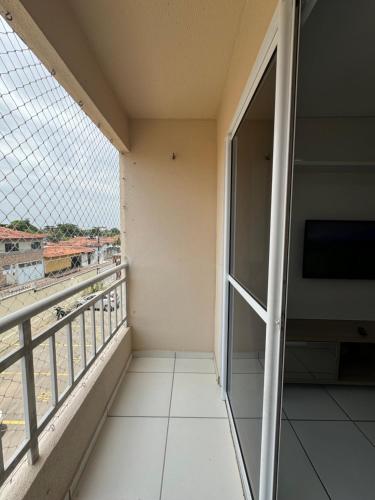 a balcony with a large window and a television at Apto com elevador, muito ventilado e aconchegante in Anil