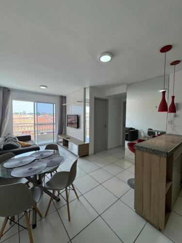 a kitchen and living room with a table and chairs at Apto com elevador, muito ventilado e aconchegante in Anil
