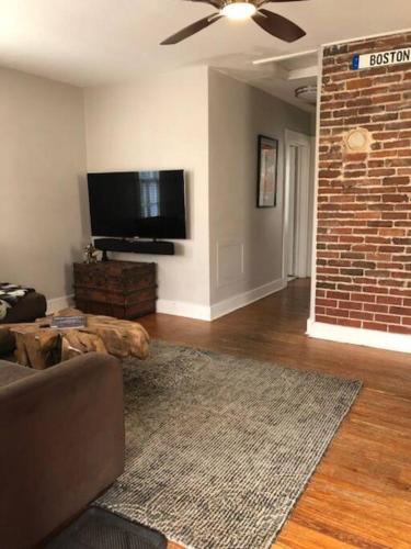 a living room with a couch and a brick wall at Habersham Hideaway in Savannah