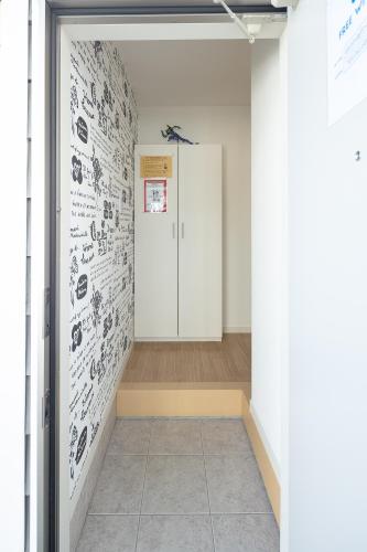 a hallway with a wall with drawings on it at Happytown6 in Kani