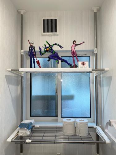 two figurines on top of a shelf in a bathroom at Happytown6 in Kani