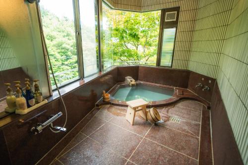wanna w łazience z oknem w obiekcie Villa Tombo Hakone w mieście Hakone