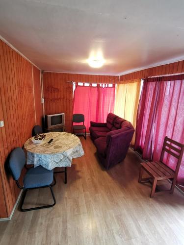 a living room with a table and a couch at Hostal y Cabañas Maribel Zuñiga in Valdivia