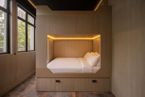 a small bed in a room with a window at Cube Social Boutique Capsule Hotel at Boat Quay in Singapore