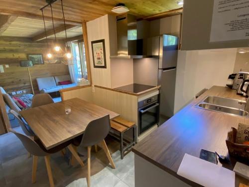une cuisine et une salle à manger avec une table en bois dans l'établissement Duplex 3 chambres pour 6 pers, proche village, ski aux pieds - FR-1-459-230, à La Clusaz