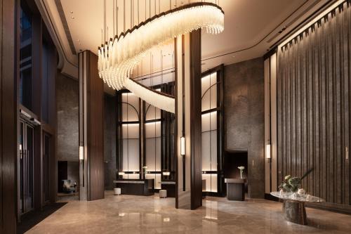 una hall con un grande lampadario a braccio in un edificio di Dorsett Kai Tak a Hong Kong