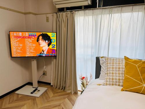 a bedroom with a bed with a flat screen tv at Shinjuku -JX house SJ0284 in Tokyo