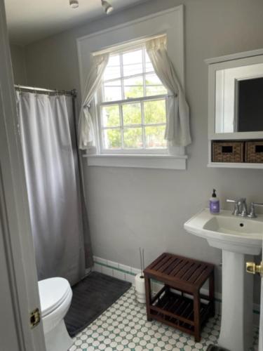 a bathroom with a toilet and a sink and a window at Habersham Hideaway in Savannah