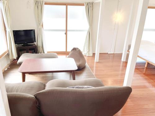 a living room with two couches and a table at かぐら庵 in Kitakata