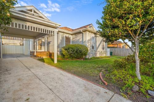 a white house with a tree and a driveway at Elegant Luxury - Family Entertainer in Ringwood in Ringwood