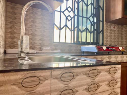 a kitchen with a sink and a window at Sweet Family & Friendly home in Kunduchi in Dar es Salaam