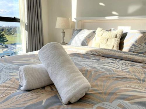 a pair of white socks on a bed with a window at Modern Chic Apartment Close to Sydney Airport in Sydney