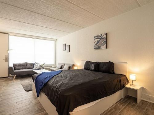 a bedroom with a large bed and a living room at Elegant 1BR Haven in Orlando & 5 minutes to Disney in Vineland