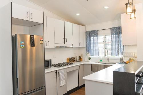 a kitchen with white cabinets and a stainless steel refrigerator at Rekindle Stay in Nadi