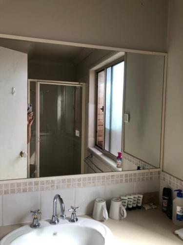 a person taking a picture of a bathroom mirror at Sky BnB room with own bathroom in Gold Coast
