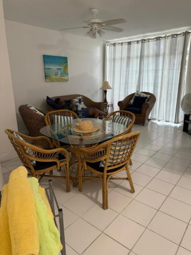a living room with a glass table and chairs at Sunset Cove - Vacation In Paradise! in Nassau